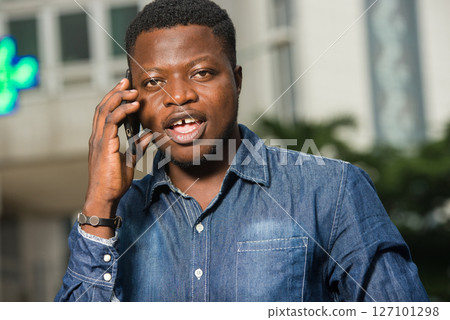 close-up of young african man with mobile phone, happy. close-up of young african man with mobile phone, happy. 127101298