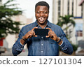 young happy man holding a smart phone young happy man holding a smart phone 127101304