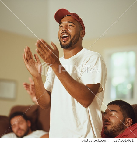 Excited man reacting to game, friends relaxing on couch 127101461