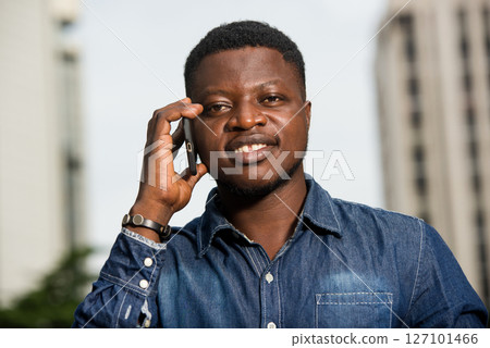 close-up of young african man with mobile phone, happy. close-up of young african man with mobile phone, happy. 127101466