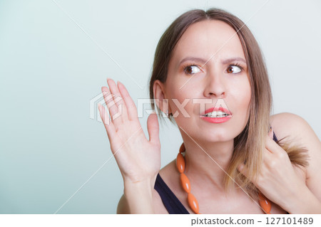 Gossip girl eavesdropping with hand to ear. Gossip girl eavesdropping with hand to ear. 127101489