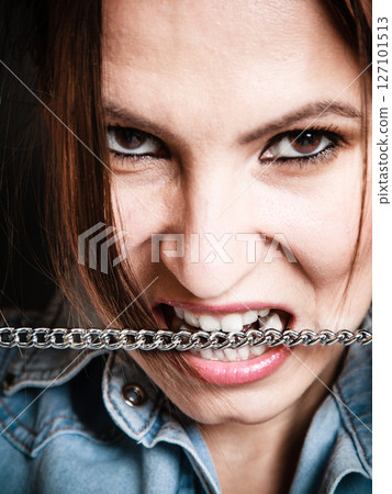 Angry woman mad girl biting metal chain Angry woman mad girl biting metal chain 127101513