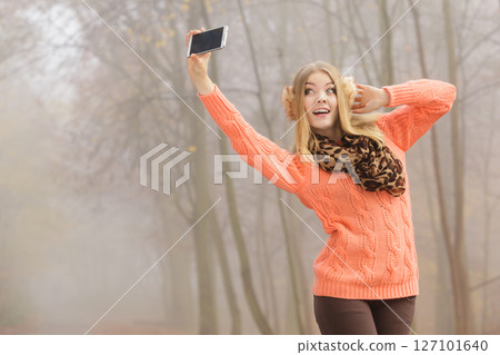 Happy fashion woman in park taking selfie photo. Happy fashion woman in park taking selfie photo. 127101640