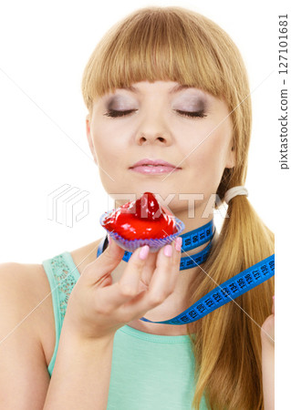 Woman holds cupcake trying to resist temptation Woman holds cupcake trying to resist temptation 127101681