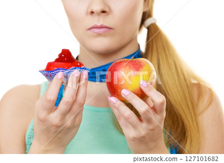 Woman choosing fruit or cake make dietary choice Woman choosing fruit or cake make dietary choice 127101682