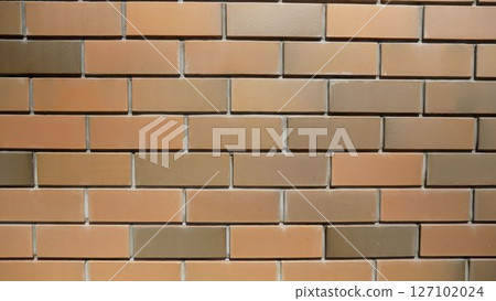 Modern brick wall showing alternating colors of brown and beige bricks creating a visually appealing pattern 127102024