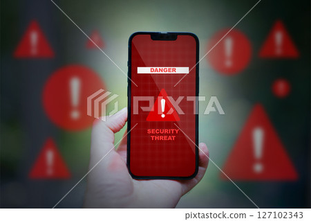 hand holding smartphone with red caution danger app icons 127102343