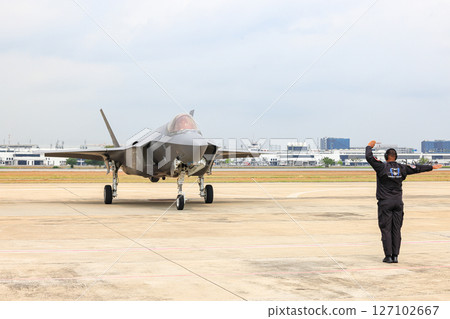 Airbase marshalling supervisor at the airbase apron on duty to take F35 taxiing to the parking place. 127102667