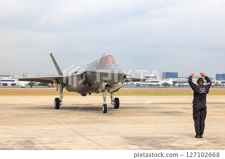 Airbase marshalling supervisor at the airbase apron on duty to take F35 taxiing to the parking place. 127102668