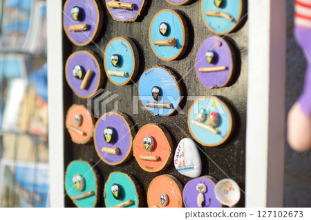 Sale of magnets, postcards, bottle openers, bookmarks, calendars, key rings and other souvenirs on street of Montenegro towns. 127102673