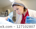 Gynecologist examines a patient laying on gynecological chair using medical vaginal speculum. Doctor takes pap smear test from a young woman cervix. Diagnosis of diseases. Woman reproductive health. 127102807