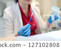 Gynecologist examines a patient takes a smear from a woman cervix. Close up view of doctor hands with gynecological cytobrush. Diagnosis of female viral and infection diseases. 127102808