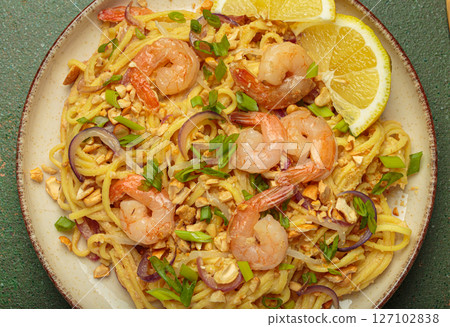 Pad thai noodles with shrimps, peanuts, green onions and lemon slice close up 127102838
