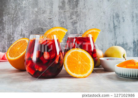 Refreshing summer sangria cocktail with fruits and berries in glasses on the table Refreshing summer sangria cocktail with fruits and berries in glasses on the table 127102986
