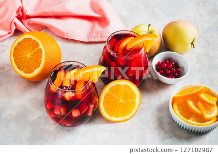 Sangria cocktail with red wine and fruits in glasses on table Sangria cocktail with red wine and fruits in glasses on table 127102987