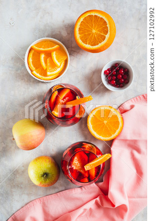 Sangria cocktail with red wine and fruits in glasses on table top and vertical view 127102992