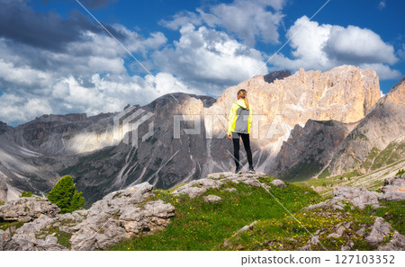 Girl on the hill with yellow flowers and green grass in mountain Girl on the hill with yellow flowers and green grass in mountain 127103352