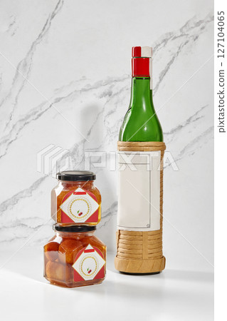 Luxardo maraschino liqueur bottle and baba al maraschino jars displayed on marble surface Luxardo maraschino liqueur bottle and baba al maraschino jars displayed on marble surface 127104065