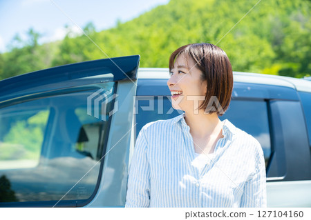 A woman on a road trip in a car Car and woman A woman on a road trip in a car Car and woman 127104160