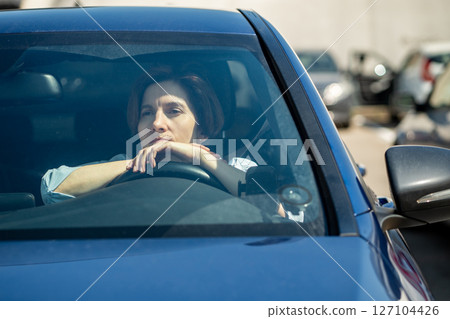 Depressed stressed middle aged woman driver sits in car on parking in city. 127104426