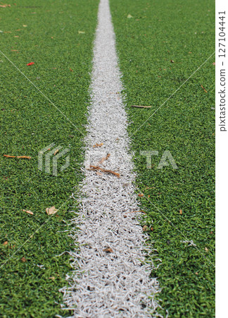 The receding distance is a straight white line on the artificial turf of the football field 127104441