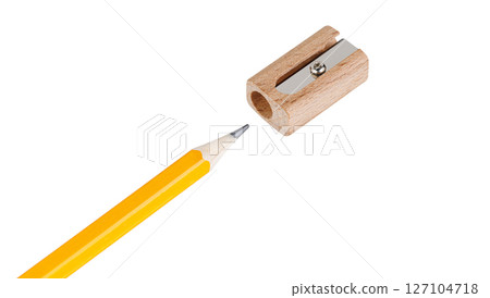 Wooden sharpener sharpening a yellow pencil on white backdrop in macro shot. Ideal for education and stationery worldwide. Wooden sharpener sharpening a yellow pencil on white backdrop in macro shot. Ideal for education and stationery worldwide. 127104718