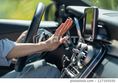 Female hand checks flow of cold air from air conditioner inside car, suffer from heat in vehicle Female hand checks flow of cold air from air conditioner inside car, suffer from heat in vehicle 127105030
