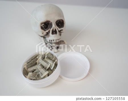 Skull Chewing Tobacco on a White Table. Skull Chewing Tobacco on a White Table. 127105558