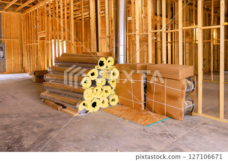 Insulation materials are neatly stacked on concrete floor within construction site undergoing renovation work. Insulation materials are neatly stacked on concrete floor within construction site undergoing renovation work. 127106671