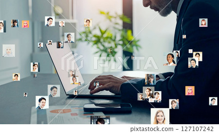 Conceptual visual of a man and multinational people using a laptop 127107242