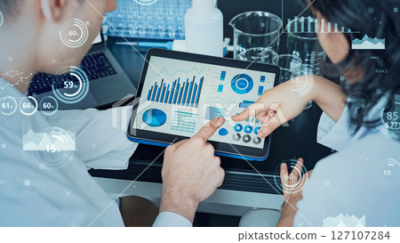 Researcher studying while looking at a tablet and statistical data concept Researcher studying while looking at a tablet and statistical data concept 127107284