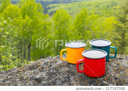 Colorful camping Cups on Rocks Overlooking Valley Colorful camping Cups on Rocks Overlooking Valley 127107388