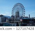 A rooftop Ferris wheel shining against the blue sky 127107428