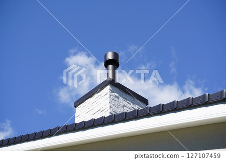 Blue sky and wood stove chimney 127107459