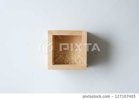 A small amount of rice left in a wooden box on a white background 127107485