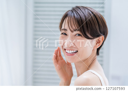 A middle-aged woman doing her skin care in the morning. A middle-aged woman doing her skin care in the morning. 127107593