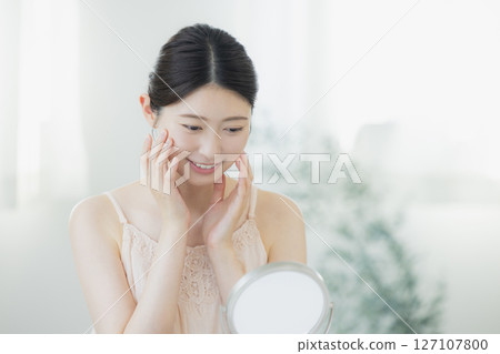 一名年輕女子正在做皮膚護理 一名年輕女子正在做皮膚護理 127107800