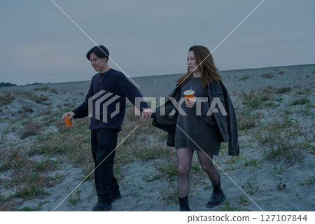 陰天的夜晚，年輕男女穿越沙丘 127107844