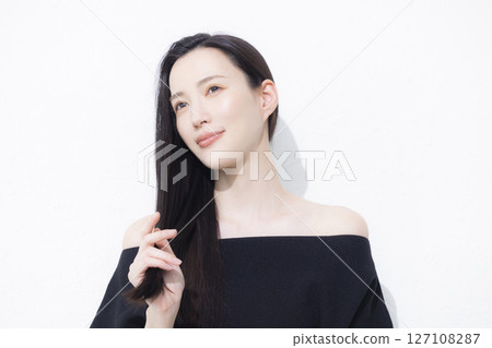 A woman wearing a black off-the-shoulder 127108287