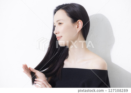 A woman wearing a black off-the-shoulder 127108289