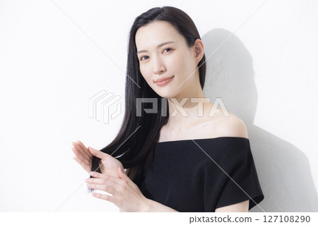 A woman wearing a black off-the-shoulder A woman wearing a black off-the-shoulder 127108290