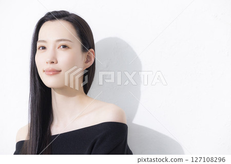 A woman wearing a black off-the-shoulder A woman wearing a black off-the-shoulder 127108296