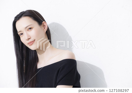 A woman wearing a black off-the-shoulder 127108297