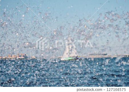 Sailing regatta in the Gulf of Finland at sunset, sailing yacht competing in a race, splashing water from under the boat, teamwork, board the boat 127108575