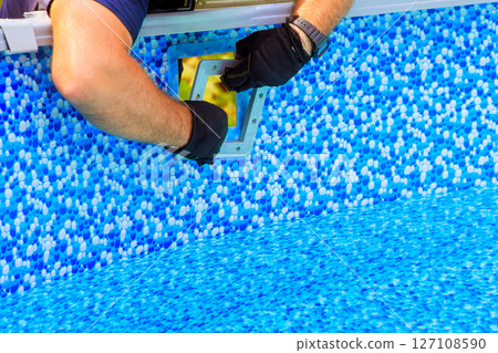 Craftsman carefully installs new pool filtration system over liner at home backyard Craftsman carefully installs new pool filtration system over liner at home backyard 127108590