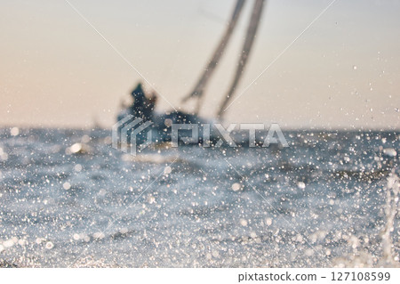 Sailing regatta in the Gulf of Finland at sunset, sailing yacht competing in a race, splashing water from under the boat, teamwork, board the boat 127108599