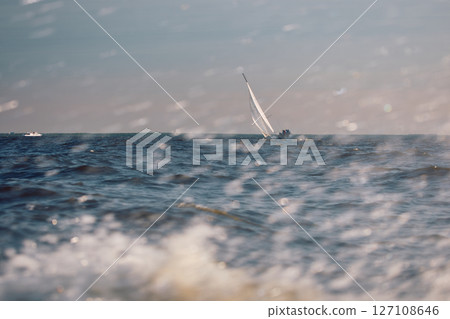 Sailing regatta in the Gulf of Finland at sunset, sailing yacht competing in a race, splashing water from under the boat, teamwork, board the boat 127108646