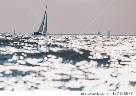 Sailing regatta in the Gulf of Finland at sunset, sailing yacht competing in a race, splashing water from under the boat, teamwork, board the boat 127108677