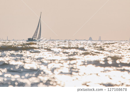 Sailing regatta in the Gulf of Finland at sunset, sailing yacht competing in a race, splashing water from under the boat, teamwork, board the boat Sailing regatta in the Gulf of Finland at sunset, sailing yacht competing in a race, splashing water from under the boat, teamwork, board the boat 127108678