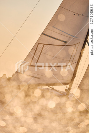 Sailing regatta in the Gulf of Finland at sunset, sailing yacht competing in a race, splashing water from under the boat, teamwork, board the boat 127108688